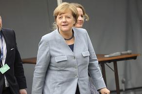 Angela Merkel falls to the floor as she trips over on stage - VIDEO
